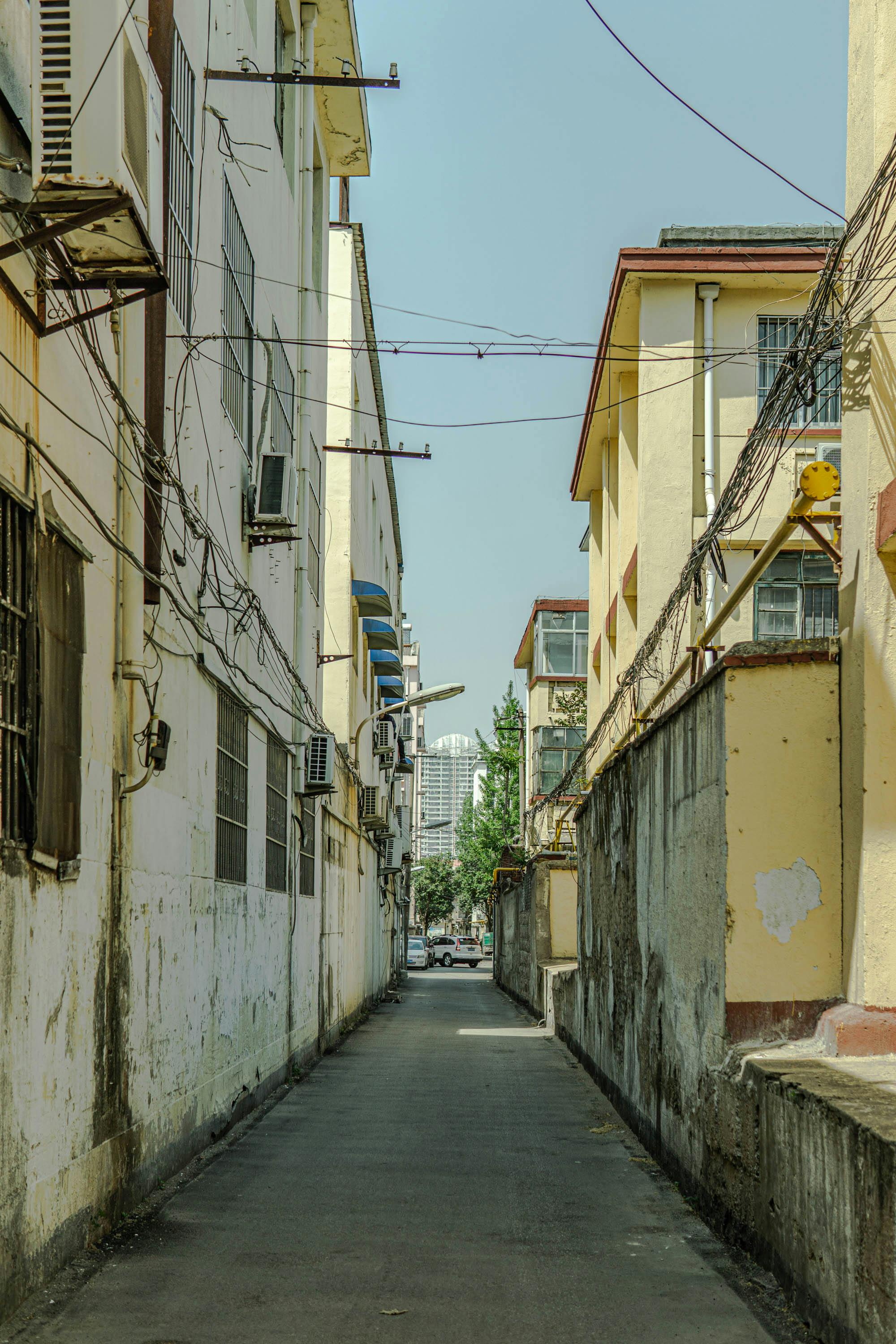 A narrow street with buildings and power lines